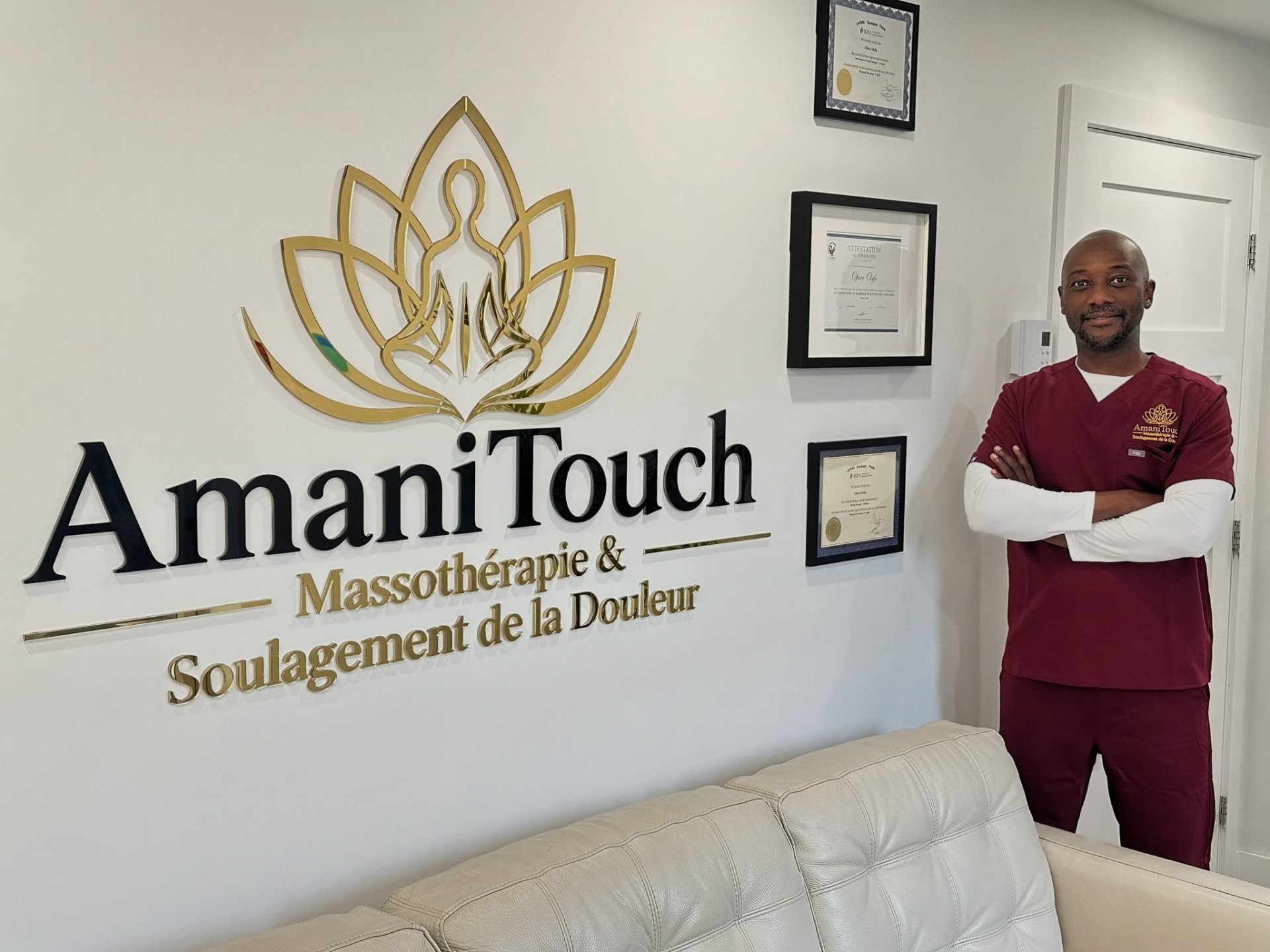 Ofure Osifo devant le logo AmaniTouch dans la clinique